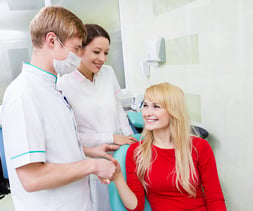 Closeup portrait dentist, doctor, assistant congratulate happy, smiling patient for successful operation procedure, isolated background clinic office. Patient visit treatment, satisfaction. Expression