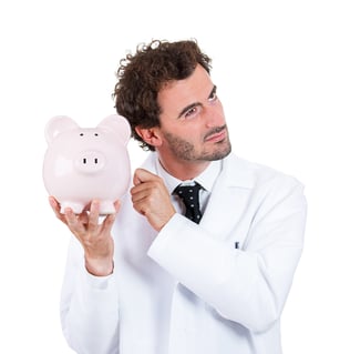 Closeup portrait, health care professional, scientist,  pharmacist, doctor, nurse knocking on piggy bank, listening to see if there is money, isolated on white background. Health care reform-1