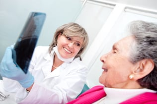 Dentist with an elder female patient looking at an x-ray