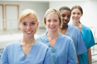 Female nurse looking at camera in hospital hallway