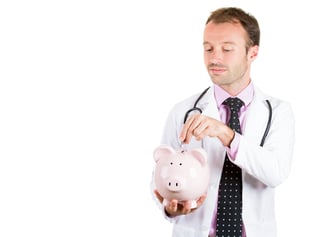 Healthcare reform concept- doctor holding piggy bank and about to drop a coin in it. Medical insurance, medicare reimbursement Happy male doctor, nurse with piggy bank isolated on a white background.