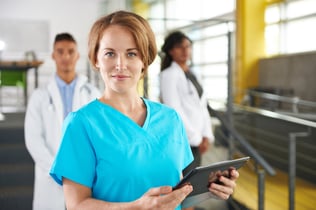 Portrait of a friendly caucasian female doctor and team in bright modern office